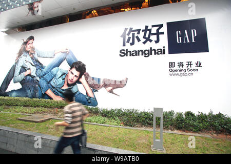 Ein chinesischer Mann Vergangenheit eine Anzeige für Lücke in Shanghai, China, 24. Oktober 2010. Uns Textileinzelhändler Lücke wird zwei Filialen in Shanghai geöffnet, auf Stockfoto