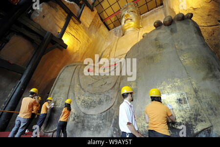 Chinesische Arbeiter regild Eine alte Buddha Statue in der Großen Buddha Tempel Tongnan in Chongqing, China, 26. Mai 2010. In der Tang Dynastie (AD 618-9 gebaut Stockfoto