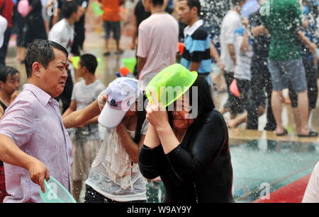 Chinesen Spritzwasser in einem großen Brunnen Wasser während einer Feier für die Water-Splashing Festival in Hangzhou City, Xishuangbanna Dai zu speichern. Stockfoto