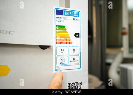Paris, Frankreich, 23.Juni, 2019: Junger Mann lesen Energy Label vor der Installation neue tragbare Klimaanlage AC im heißen Sommer in seinem Wohnzimmer Clatronic Stockfoto