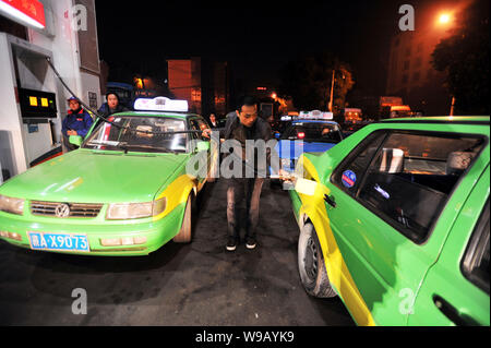 Einem chinesischen Taxifahrer tankt sein Auto an der Tankstelle vor der Kraftstoffpreise sind in Nanchang city aktualisiert, East China Provinz Jiangxi, 21. Dezember Stockfoto