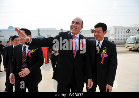 Muhtar Kent, Mitte, Vorsitzender und CEO von The Coca-Cola Company, Wellen, die an den chinesischen Arbeitern während der Eröffnungsfeier der Abfüllanlage von Swire Co Stockfoto