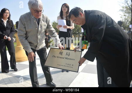 Bernie Ecclestone (L), kommerzielle Supremo der Formel 1 (F1), stellt das Typenschild einer Gruppe von Statuen auf dem Shanghai International Circuit Stockfoto