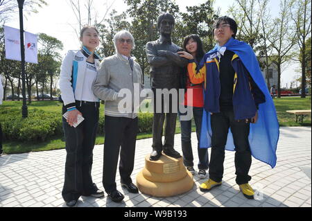 Bernie Ecclestone (L2), kommerzielle Supremo der Formel 1 (F1), steht neben einer Statue von ihm auf dem Shanghai International Circuit Park in Shang Stockfoto