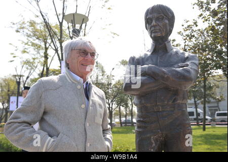 Bernie Ecclestone, kommerzielle Supremo der Formel 1 (F1), stellt neben einer Statue von ihm auf dem Shanghai International Circuit Park in Shanghai, C Stockfoto