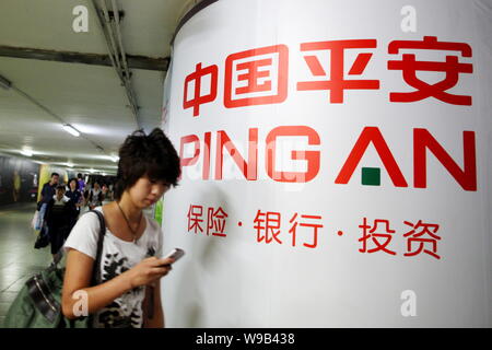 ------ Lokale chinesische Bewohner vorbei an einer Werbung für Ping von China in Peking, China, 4. September 2009. Ping An Insurance (Group) Co., Stockfoto
