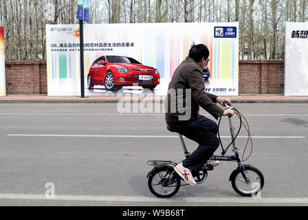 Ein chinesischer Mann fährt mit dem Fahrrad auf einer Straße in Peking, China, 26. April 2010. Die Stadt Peking, geordneter als die Welten schlechtesten Verkehr, hat p Stockfoto