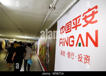 ------ Lokale chinesische Bewohner vorbei an einer Werbung für Ping von China in Peking, China, 4. September 2009. Ping An Insurance (Group) Co., Stockfoto