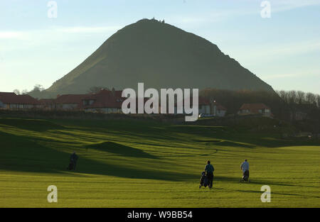 Golfer spielen auf dem Glen Golf Course, North Berwick, Schottland vor der dramatischen Kulisse der North Berwick Gesetz. Stockfoto