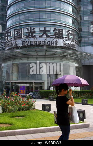 Eine chinesische Frau geht vorbei an einem Zweig von China Everbright Bank in Chongqing, China, August 8, 2010. Eine kürzlich durchgeführte Börsengang von Landwirtschaftlichen Bank von Ch Stockfoto