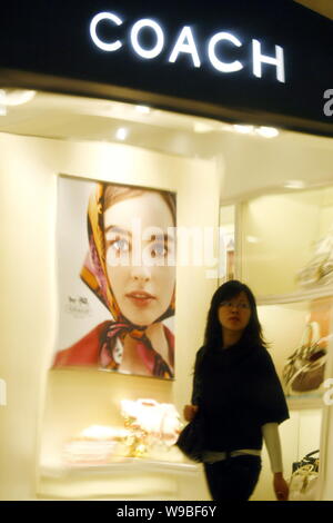 ---- Eine junge chinesische Frau geht vorbei an einer Boutique Trainer an einer Shopping Mall in Shanghai, China, 9. April 2009. Mit einem schnelleren Wachstum als seine zu Stockfoto