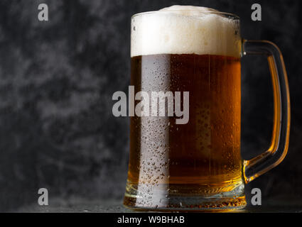 Eine Tasse helles Bier auf einem dunklen konkreten Hintergrund Stockfoto