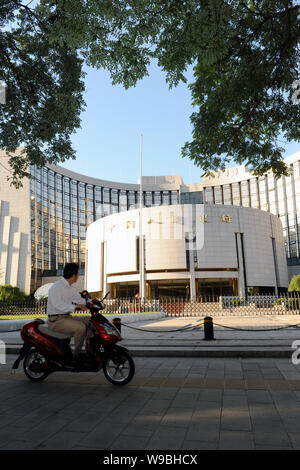 Ein chinesischer Mann fährt mit dem Fahrrad hinter dem Sitz und Hauptverwaltung der Völker Bank of China (Pboc), China Zentralbank, in Peking, China, Sep Stockfoto