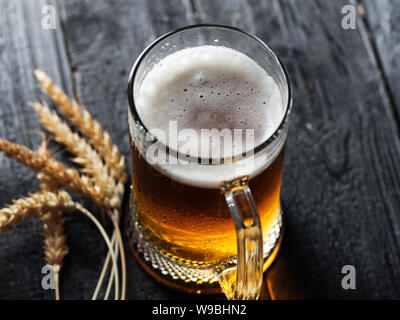 Bierkrug mit hellen Bier auf dunklem Hintergrund Stockfoto