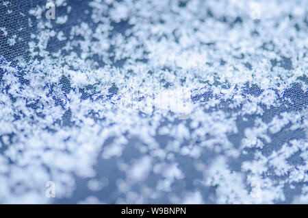 Makro Foto des echten Schnee Kristall. Schneeflocke auf dem blauen Hintergrund. Mode Hintergrund mit weißen Schneeflocken Stockfoto