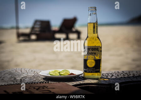 Einzelne Flasche Corona Bier am Strand mit einer Seite der Kalk