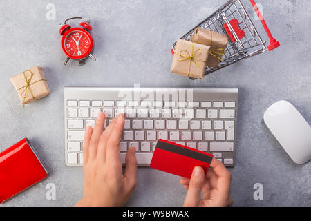 Frau Hände Geschenke online zu bestellen, Bezahlung per Kreditkarte. Konzept online shopping Geschenke zu kaufen. Red Kreditkarte, keyborad und Weihnachtsgeschenke auf Stockfoto