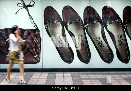 ---- Eine junge chinesische Frau an eine Werbung für Salvatore Ferragamo Schuhe in Shanghai, China, 28. September 2009. Verkauf von Luxusgütern Stockfoto