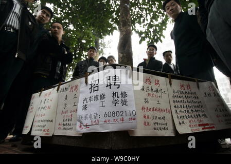 Arbeitslose Chinesische Wanderarbeiter Blick auf Werbung für Anstellungen auf einer Straße in Chongqing, China, Sonntag, den 8. Februar 2009. Eine Umfrage durchgeführt. Stockfoto