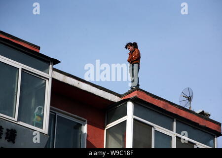 Eine junge Chinesin, die beabsichtigen Selbstmord auf einem Wohngebiet Apartment Gebäude in Changchun Stadt zu sehen ist, im Nordosten Chinas in der Provinz Jilin, Montag, Stockfoto