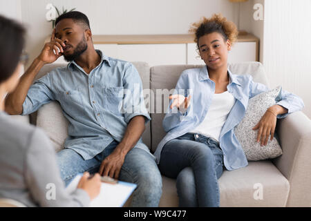 Gleichgültig Schwarz Ehegatten Sitzen auf einem Sofa im Büro des Paare Therapeuten Stockfoto