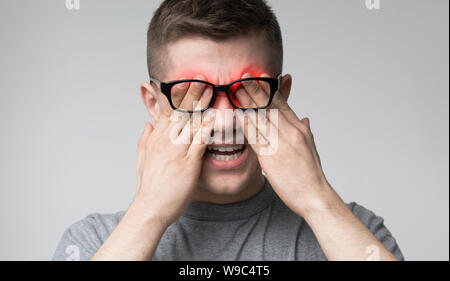 Junge Menschen leiden unter Schmerzen in den Augen nach der Arbeit mit dem Computer Stockfoto