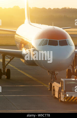 TUG Pushback Traktor mit Flugzeug auf der Landebahn am Flughafen. Stockfoto