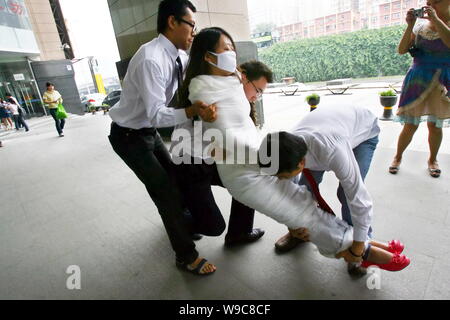 Chinesische Arbeiter versuchen, ein Kollege Studentin, die ihren Körper mit Gaze eingewickelt Unterstützung für Deng Yujiao, ein Hotel, Kellnerin, die eine Erstochen zu zeigen zu tragen Stockfoto