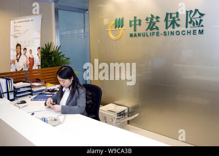 ---- Ein chinesischer Mitarbeiter an der Rezeption des Amtes für Manulife-Sinochem in Shanghai, 28. März 2008. Ausländische Unternehmen Anteil der f Stockfoto