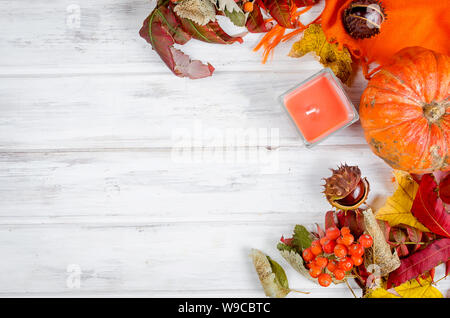 Kastanien in der Shell, Kerze im Glas und herbstliche gefallen Ahornblätter auf der hölzernen Hintergrund, fallen noch Leben Stockfoto