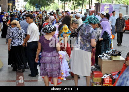 Lokalen chinesischen Uigurischen Bürger vorbei zur Straße Anbieter auf einer Straße in Urumqi im Nordwesten Chinas Autonome Region Xinjiang Uygur, 12. Juli 2009. L Stockfoto