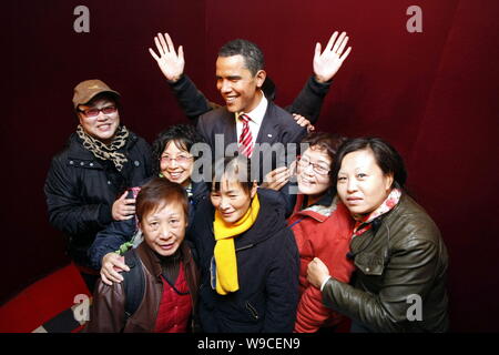 Chinesische Besucher stellen neben einer Wachsfigur von US-Präsident Barack Obama an der Madame Tussauds Wax Museum in Shanghai, China, 16. November 2009. Ein Stockfoto