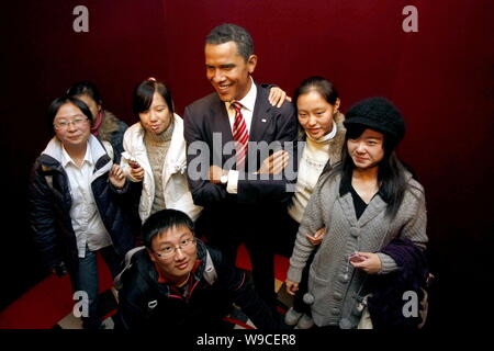 Chinesische Besucher stellen neben einer Wachsfigur von US-Präsident Barack Obama an der Madame Tussauds Wax Museum in Shanghai, China, 16. November 2009. Ein Stockfoto