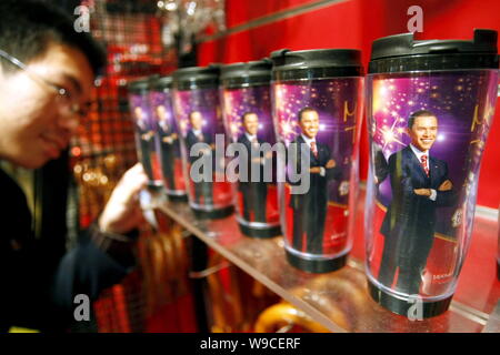 Ein chinesischer Besucher sucht an Souvenirs mit einem Bild der Wachsfigur von US-Präsident Barack Obama an der Madame Tussauds Wax Museum in Shanghai, Ch Stockfoto