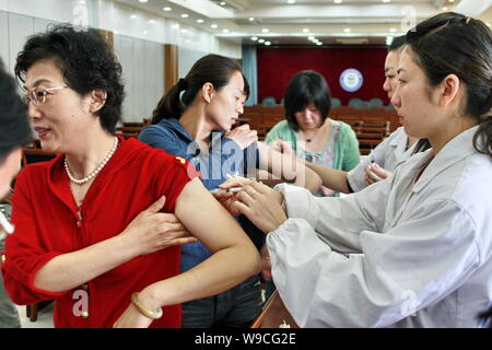 ------ Chinesische medizinische Arbeiter injizieren Sie Mitarbeiter einer Firma mit Hepatitis-B-Impfstoffen in Shangrila City, East China Provinz Anhui, 14. Mai 2008. Chi Stockfoto