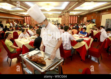 ---- Einen chinesischen Koch slice eine gebratene Ente in einem Quanjude gebratene Ente Restaurant an der Wangfujing Einkaufsstraße in Peking, China, 12. Juni 2007. Qua Stockfoto