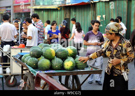 Lokalen chinesischen Uigurischen Bürger vorbei an Ständen auf einer Straße in Urumqi im Nordwesten Chinas Autonome Region Xinjiang Uygur, 12. Juli 2009. Recht und Ordnung Stockfoto