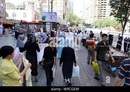 Lokalen chinesischen Uigurischen Bürger vorbei an Ständen auf einer Straße in Urumqi im Nordwesten Chinas Autonome Region Xinjiang Uygur, 12. Juli 2009. Recht und Ordnung Stockfoto