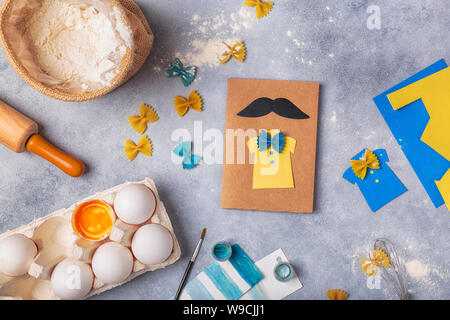 Die Grußkarte für Vatertag. Shirt mit Schmetterling von Pasta. Karte aus Papier. Schnurrbart. Kinder Kunst Projekt. Stockfoto