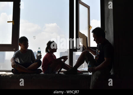 (190813) - NANCHANG, Aug 13, 2019 (Xinhua) - Tan Hongbo und seine Kinder Ruhe am Arbeitsplatz Website in Nanchang Qingshanhu Bezirk, Stadt, der ostchinesischen Provinz Jiangxi, Aug 6, 2019. Tan Hongbo, 39, und seine Frau Wang Yuanzhen, 34, sind die Wanderarbeitnehmer in Nanchang. Sie ließen ihren Sohn und Tochter Tan Tan Zheng Jinxin mit Großeltern in Duchang Kreis Conghua City. Am Sommer, Ferien, die Kinder kamen nach Nanchang mit ihren Eltern wieder zu vereinen. Tan Hongbo Paare entschieden, ihre Kinder in Nanchang zu übertragen gehen im nächsten Jahr in die Schule, wie die Ausbildung Abteilung der Qingshanhu Bezirk in Nanchan Stockfoto