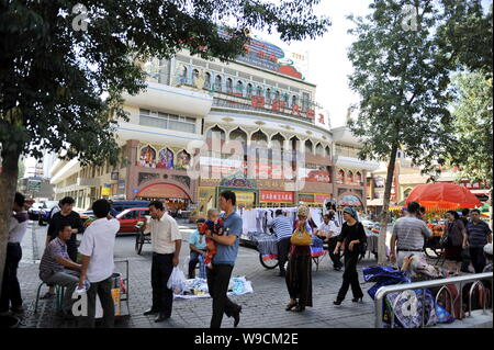 Lokalen chinesischen Uigurischen Bürger vorbei an Ständen vor dem Erdaqiao Basar in Urumqi im Nordwesten Chinas Autonome Region Xinjiang Uygur, 12. Juli 20. Stockfoto