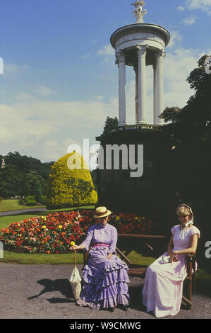Ein paar der Viktorianischen kostümierten Figuren neben dem Choragic Denkmal, Alton Towers Gärten, Staffordshire, England, UK. Ca. 80er Stockfoto