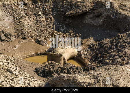 Alte dreckige rostige Ventil an der Leitung der Stadt Wasserversorgungsnetz in der Grube während der Reparatur und Austausch von Mitteilungen Stockfoto