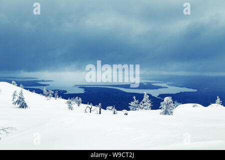 Winterlandschaft. Aus Sicht eines schneebedeckten Berges zum See. Stockfoto