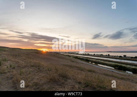 Weitwinkelaufnahme der Sonnenuntergang über Hügel mit großen Körper von Wasser auf der rechten Seite Stockfoto