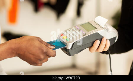Kunden bezahlen für Kleidung per Kreditkarte in Designer Boutique Stockfoto
