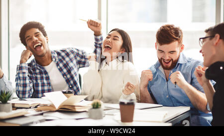 Aufgeregt Studenten feiern beendet Test in Bibliothek Stockfoto