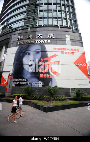 ------ Anwohner vorbei eine Werbung von China Unicom im Unicom Tower in Shanghai, China, 4. September 2009. Telefonica SA, Europa Stockfoto