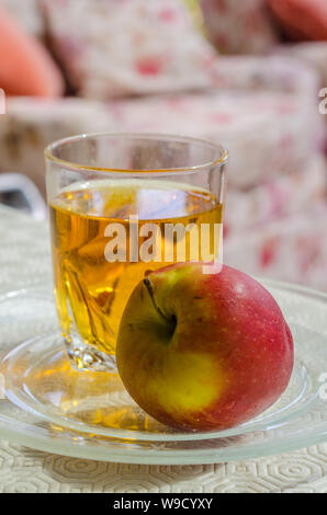 Einen Apfel und ein Glas Apfelsaft zusammen auf einen Tisch. Stockfoto