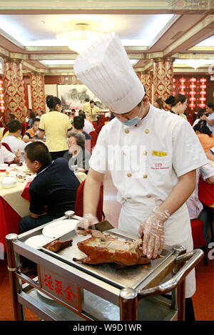 ---- Einen chinesischen Koch slice eine gebratene Ente in einem Quanjude gebratene Ente Restaurant an der Wangfujing Einkaufsstraße in Peking, China, 12. Juni 2007. Qua Stockfoto